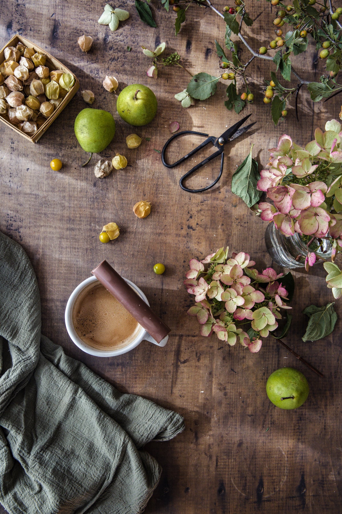 Culinary scene of apples and hot cocoa on rustic, wooden textured photography surface.