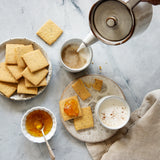 Light and airy marble photography surface with crackers, marmalade and tea