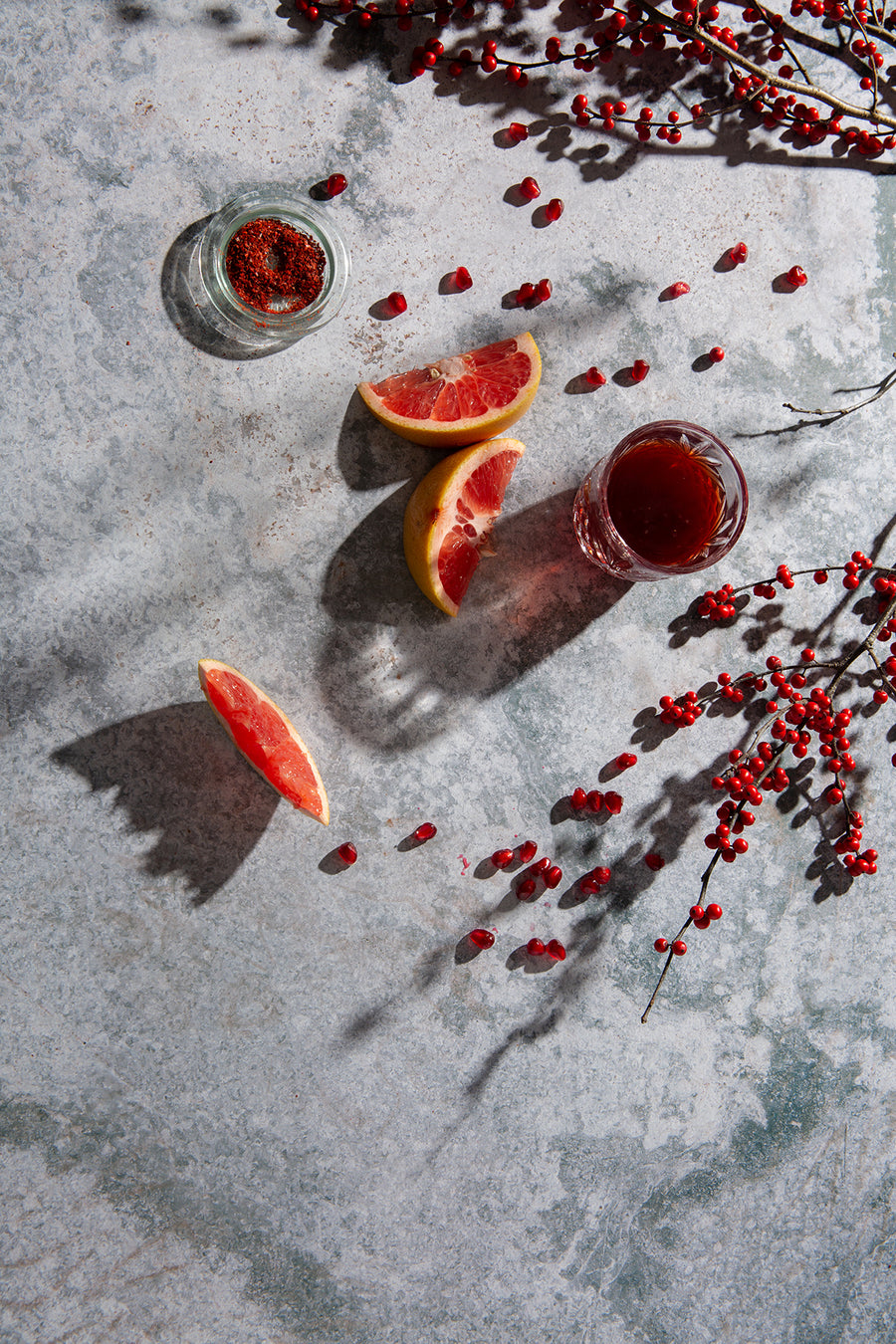 Atlas Food Photography Background with  grapefruit slices, pomegranate, seasoned salt and glass of juice