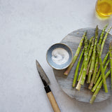 Light and airy gray stone photography surface with asparagus and olive oil