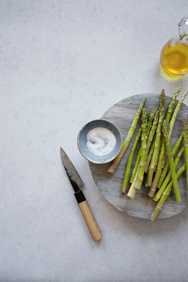 Light and airy gray stone photography surface with asparagus and olive oil