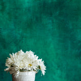Dark and moody green painted photography background with bouquet of flowers
