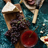Dramatic green stone photography surface with cheese, salami and fruit