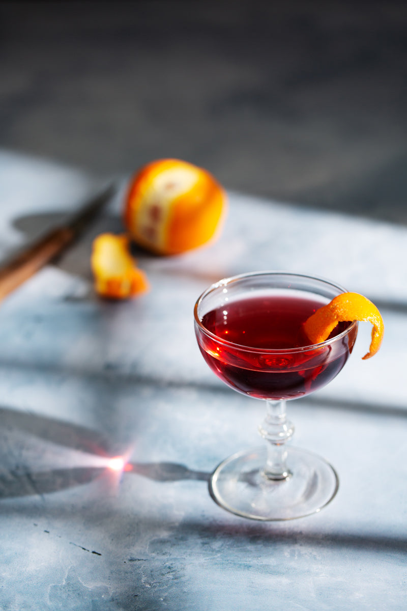 Light blue painted photography surface with red cocktail