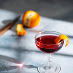 Light blue painted photography surface with red cocktail