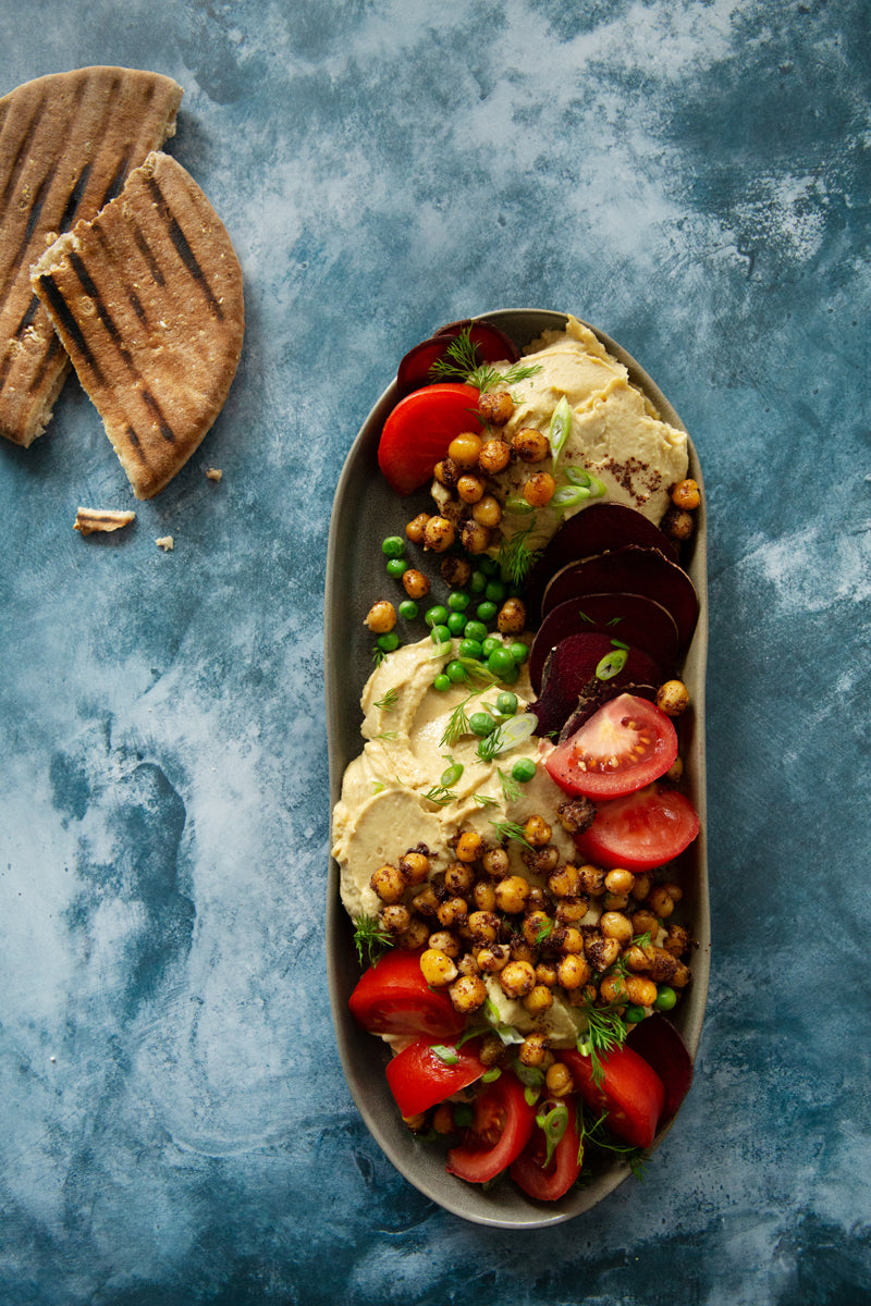 Axel Food Photography Background with platter of hummus, tomatoes, chickpeas and pita bread