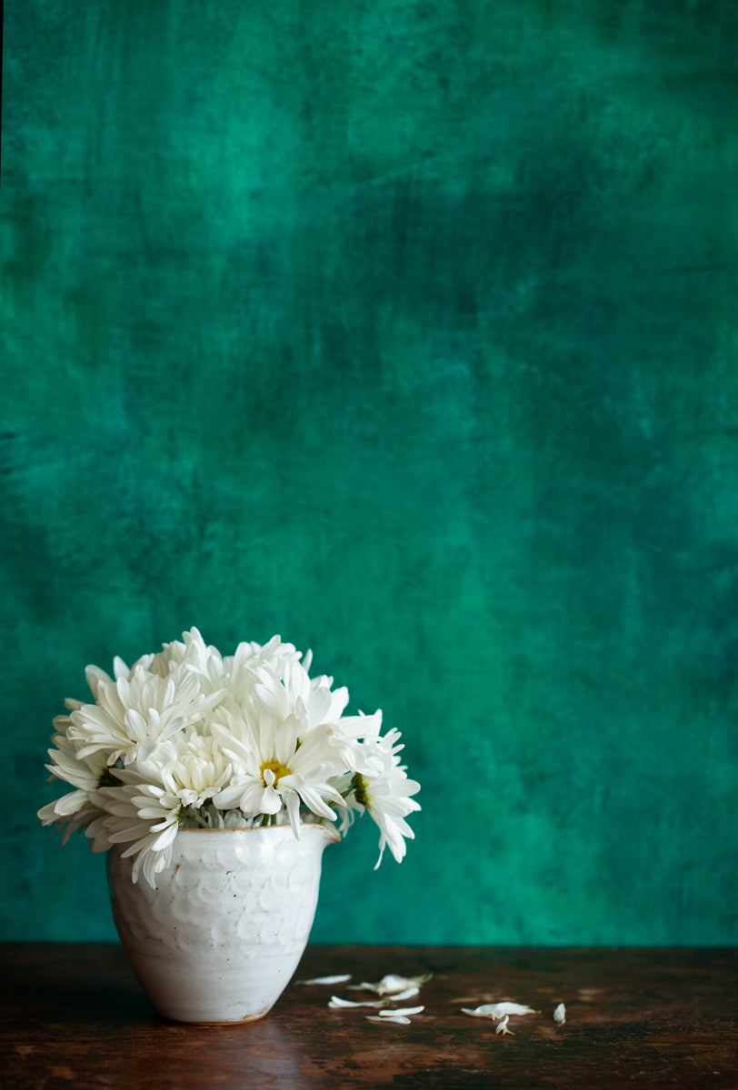 Dark and moody green painted photography background with bouquet of flowers