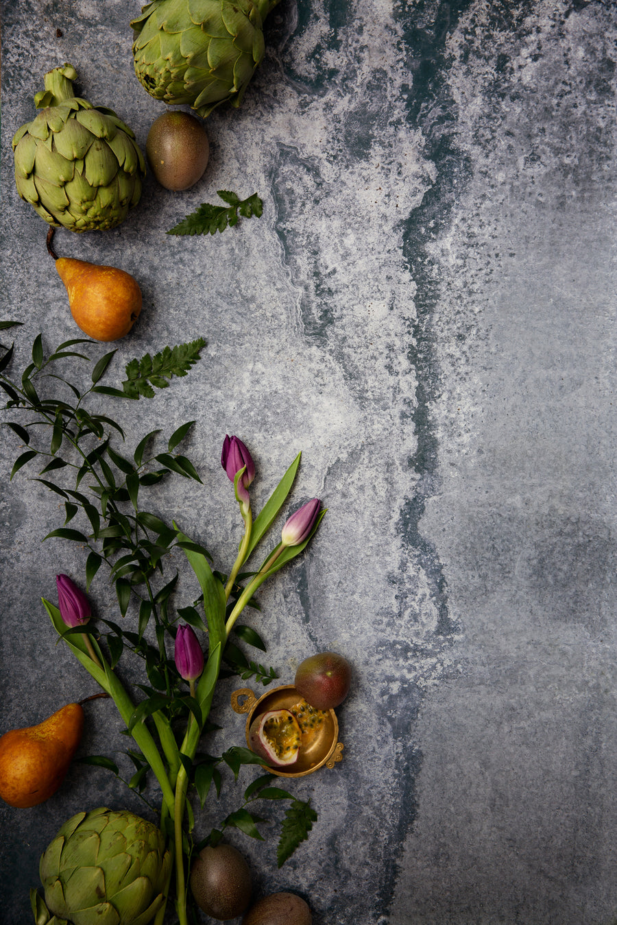 Rustic blue metal photography surface with pears, artichokes and flowers