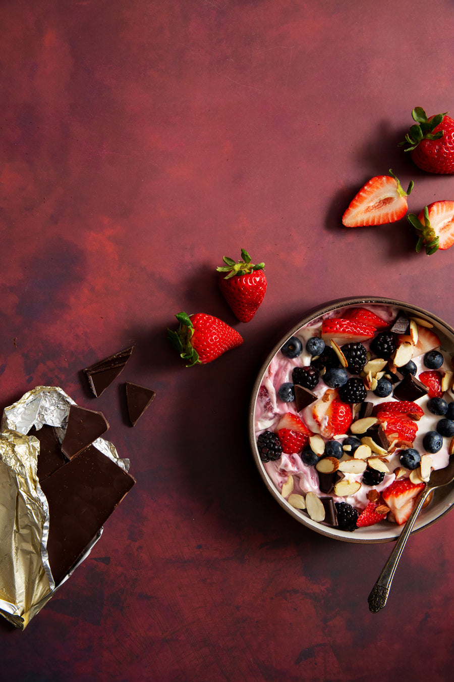Scarlet Food Photography Background with bowl of yogurt with fruit, nuts and chocolate