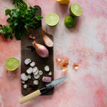 Pink painted photography surface with shallots, herbs and limes